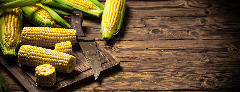 Fresh corn on wooden table.