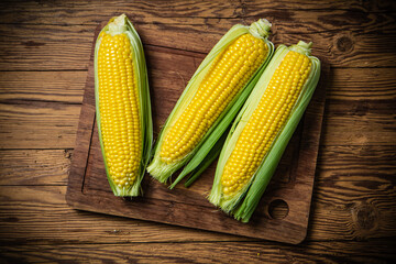 Fresh corn on wooden table.