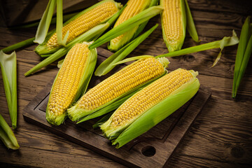 Fresh corn on wooden table.
