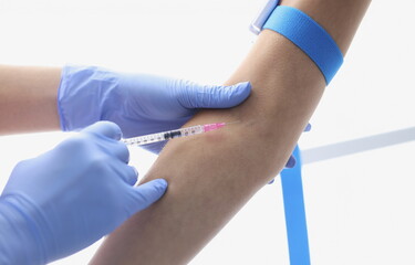 Gloved hands of doctor inject a patient into vein. How to give an intravenous injection concept