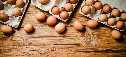 Chicken eggs on wooden table.