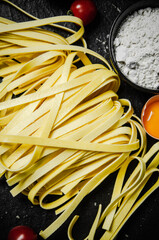 Homemade pasta tagliatelle. On black table.