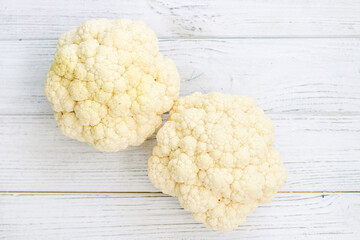 Cauliflower vegetables standing on a white wooden table