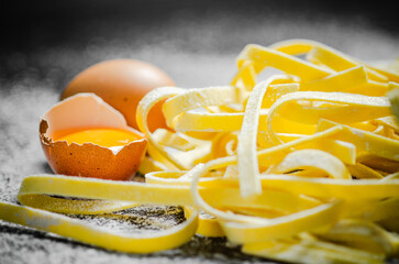 Homemade pasta tagliatelle. On black table.
