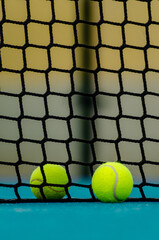 selective focus, two paddle tennis ball near the net in a blue paddle tennis court