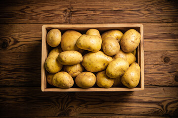 Fresh potatoes. On wooden table.