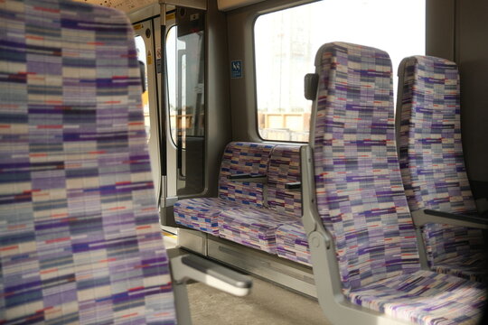 Interior seating on an empty carriage of the Elizabeth Line, demonstrating the unique purple moquette design