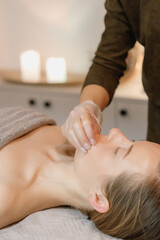 Obraz na płótnie Canvas buccal facial massage, close-up, cosmetologist makes woman a procedure on a massage table in a spa salon