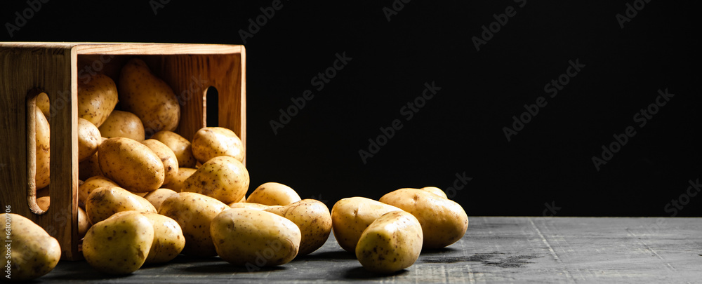 Wall mural Fresh potatoes. On black background.