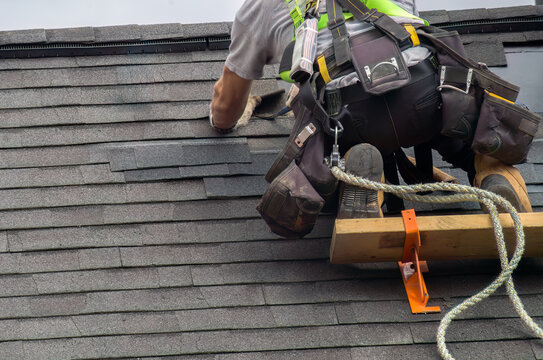 Roofer Construction Worker Ensuring Roof Maintenance with Security Rope