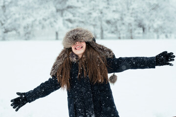 Fototapeta na wymiar cute girl having a fun with a snow in winter cold weather. Winter season joying.