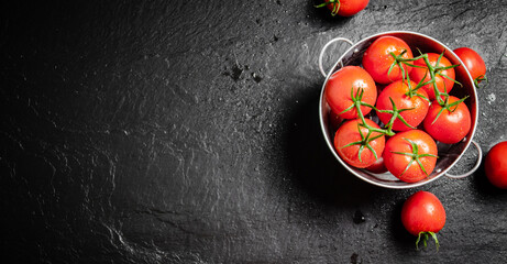 Fresh tomatoes. On black table.