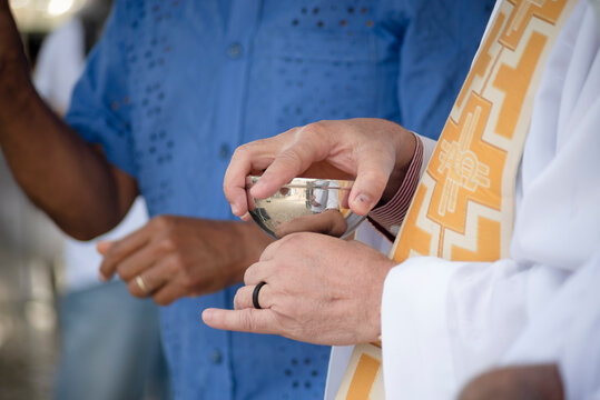 Hands of a Catholic priest holding the hostia cup during open mass at the Senhor do Bondim church in the city of Salvaldor, Bahia.