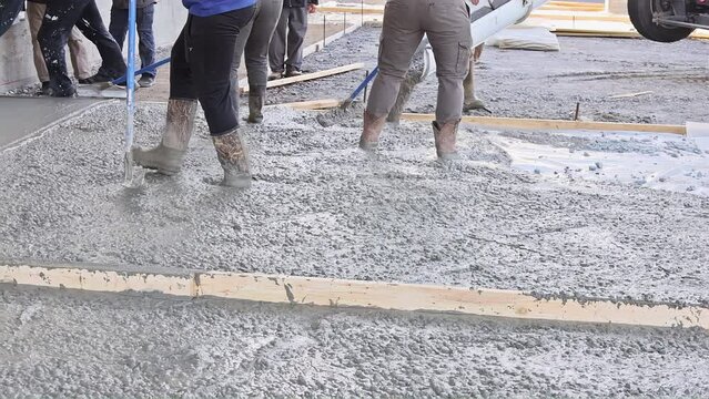 In driveway near home concrete mixer truck pours ready-mixed cement concrete for driveway using wet cement