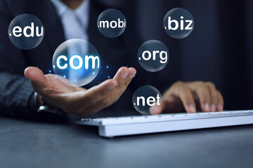 Businessman hand on working desktop holding chosen subdomain name to dot com .com to registration the commercial website. Domain website concept.