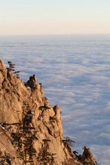 Sunlit cliffs and sea in clouds