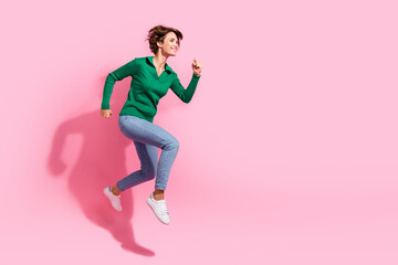 Fototapeta na wymiar Full body length view of running sporty fit young girl looking empty space motivation to work more isolated on pink color background