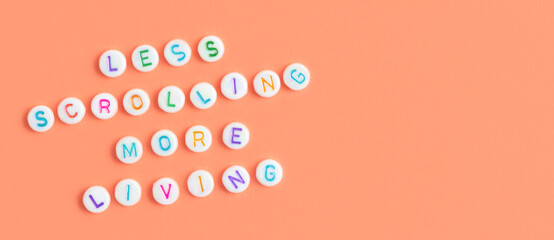 Less scrolling more living. Banner with quote made of beads with letters on a peach background.