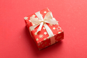 Wrapped christmas or other holiday handmade present in paper with colored ribbon. Present box, decoration of gift on table, top view with copy space