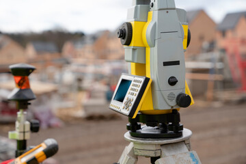 Surveyor builder site engineer with theodolite total station at construction site outdoors during surveying work