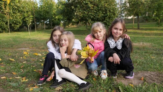 four little girls schoolgirls on a picnic in the park looking at the camera