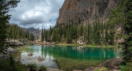 a mountain lake surrounded by tall pine trees and green rocks