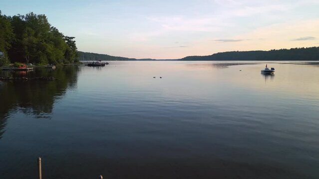 A dock extends into a calm lake at sunset