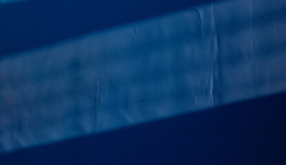 Fondo de pared azul con juego de luces y sombras. Muro de habitación interior azul con luz de la ventana.