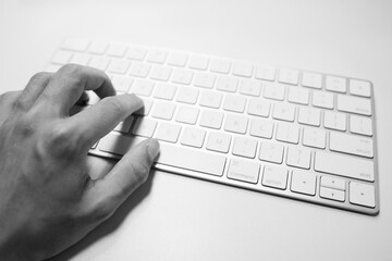 person typing on a white computer keyboard 