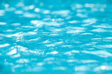 Water and air bubbles over blue background,sea wave ,Bokeh light background in the pool,Hotel swimming pool with sunny reflections.