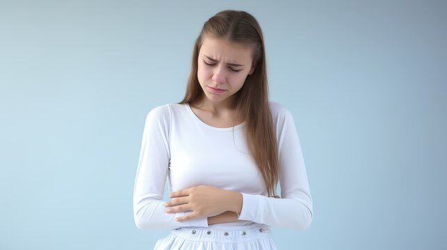 A teen girl with stomach pain infront of a clean one colored background.generative ai
