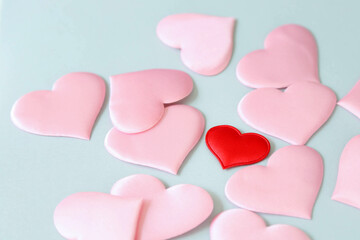 The red decorative heart is in the middle of pink hearts on a blue background.