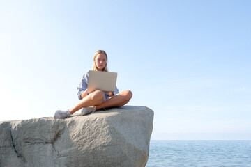 Remote work.Girl freelancer works remotely on the sea shore. workation, remote work,WFVH,Van Life...