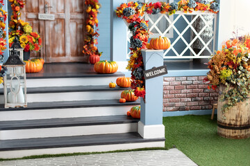 Residential house decorated for Halloween holiday. Different colored pumpkins in front door On...