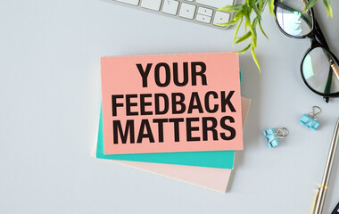 YOUR FEEDBACK MATTERS Concept. Words on notebook with white keyboard and tablet on table