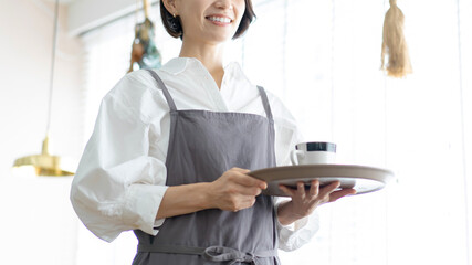 コーヒーを運ぶカフェ店員