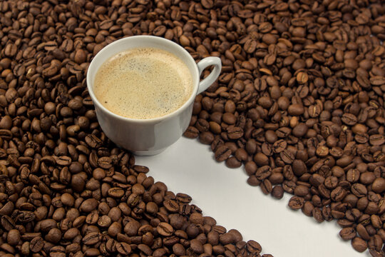 Cup of espresso coffee on a background of coffee beans © Ruzanna