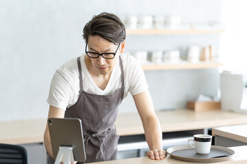 笑顔で接客するカフェ店員男性