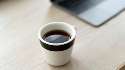 テーブルに置かれたパソコンとコーヒー