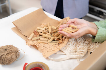 Young Asian businesswoman Clothes are being packaged for delivery to customers in cardboard boxes and cushioned lump from natural materials that are not toxic to the planet.