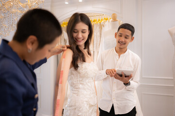 Bridal gown designers and tailors measure the size of the gown against the bride's figure when she comes to try on the gown in order to make it perfect and ready to wear on the wedding day.