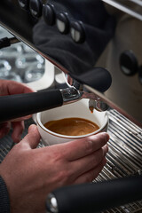 Close-up photo of a person preparing a cup of latte and coffee