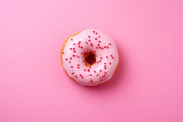 Strawberry donut with icing on pastel pink background. Sprinkled sweet and colourful glazed doughnut. Flat lay food concept	