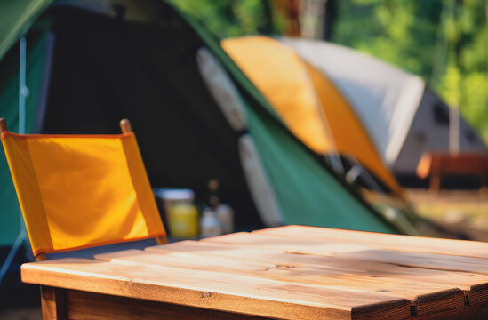 Wooden table top on blur tent camping travel tent and grass field.Fresh and Relax concept.For montage product display or design key visual layout.View of copy space.
