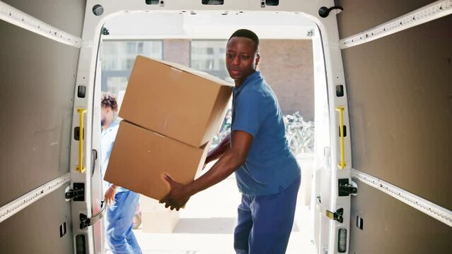Young Delivery Men Loading Cardboard Boxes