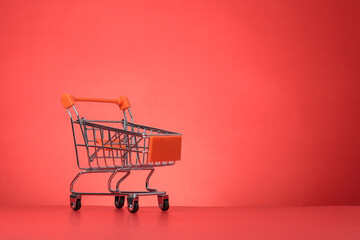 An empty shopping cart is isolated on the red background.