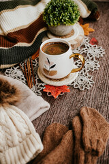 Obraz na płótnie Canvas Cozy autumn still life with cup of hot black coffee. knitted hat and scarf on wooden background
