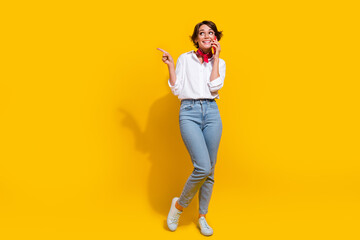Fototapeta na wymiar Photo of adorable lovely girl dressed trendy clothes looking up empty space recommend buy device isolated on yellow color background