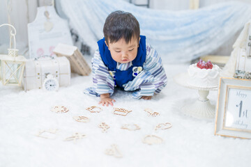バースデーフォトセットで1歳の誕生日をお祝いして選び取りをする和服姿の可愛い赤ちゃん