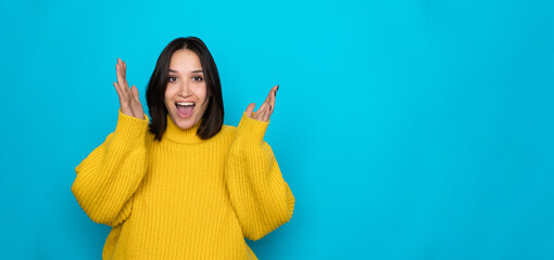 Portrait of satisfied glad woman long hairstyle wear yellow sweater raise hands up isolated on blue...